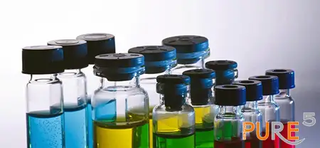 a bunch of ready solvents for the extraction in glass jars. The color varies blue, yellow, green and red. the caps are black