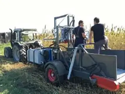 Hemp Harvester in the plant field with 2 workers and a tractor